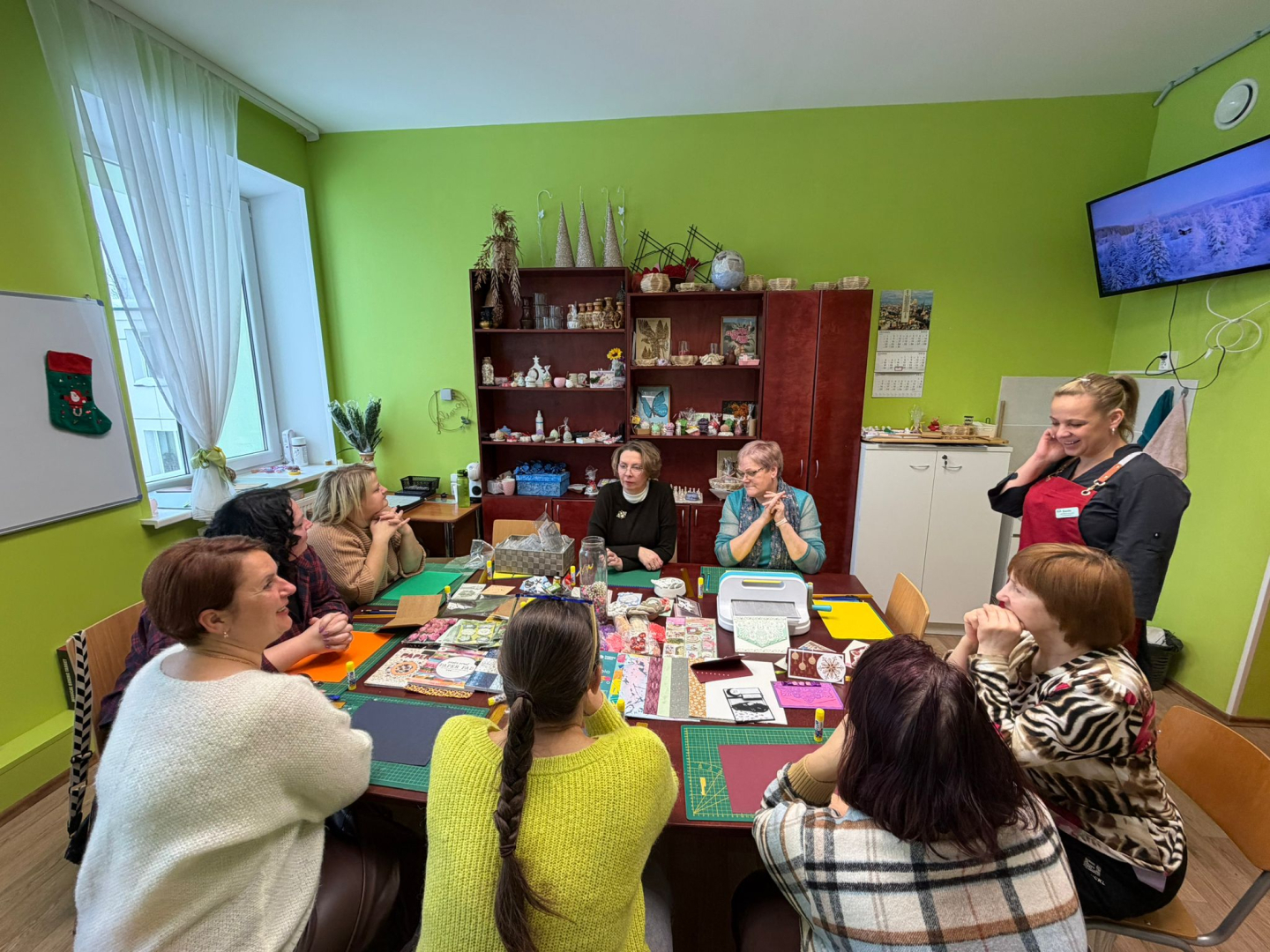 Cilvēki pie galda veido rokdarbus