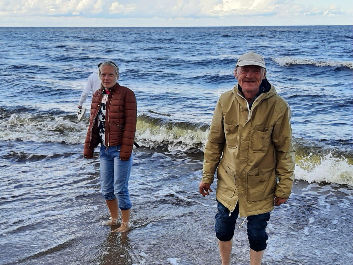 Vīrietis un sieviete bradā pa jūru
