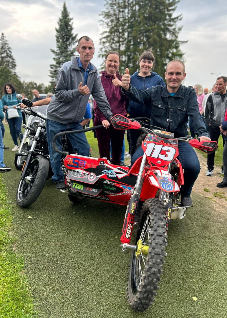 Vīrieši uz motocikla ar blakusvāģi