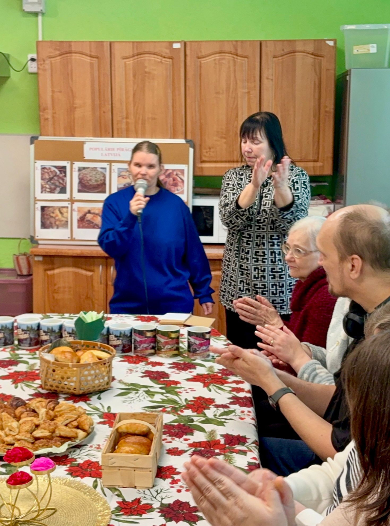 Cilvēki ap galdu gatavo pīrāgus