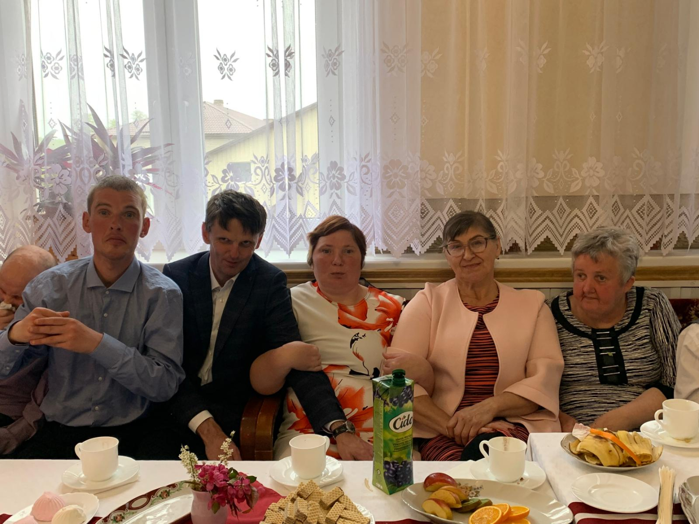 Cilvēku grupa gar svētku galdu