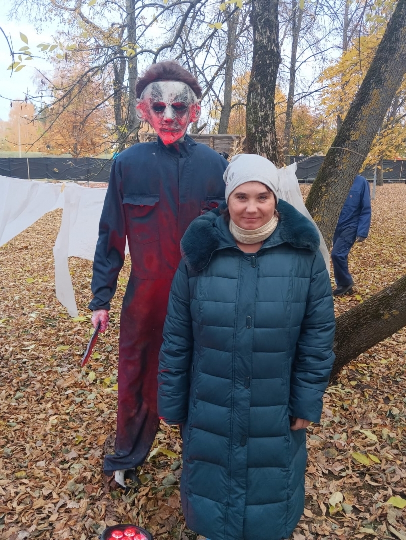 apmeklētāji ar šausmu parka dekorācijām