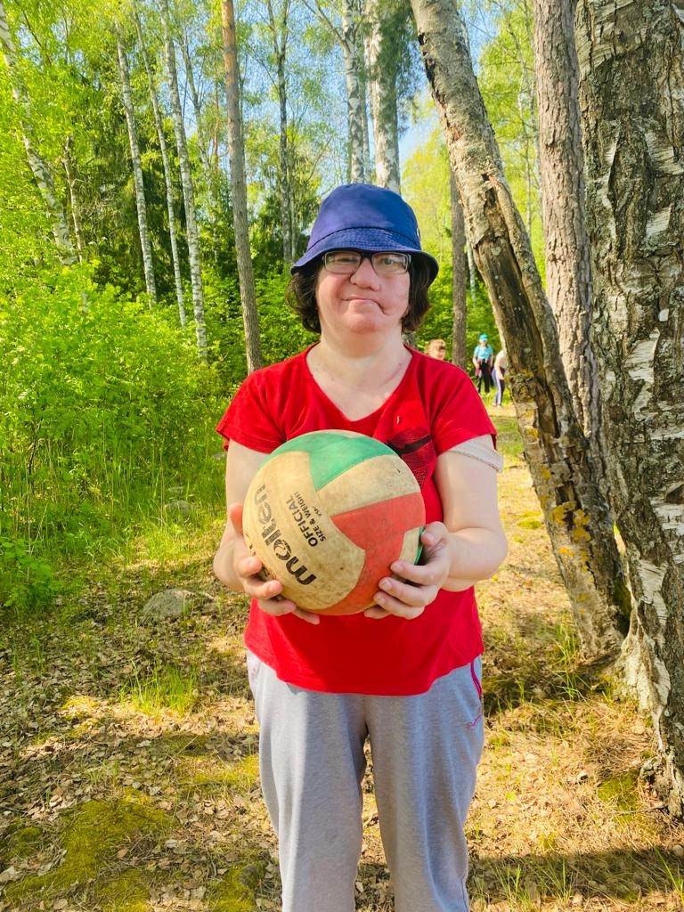 sieviete tura rokās volejbola bumbu