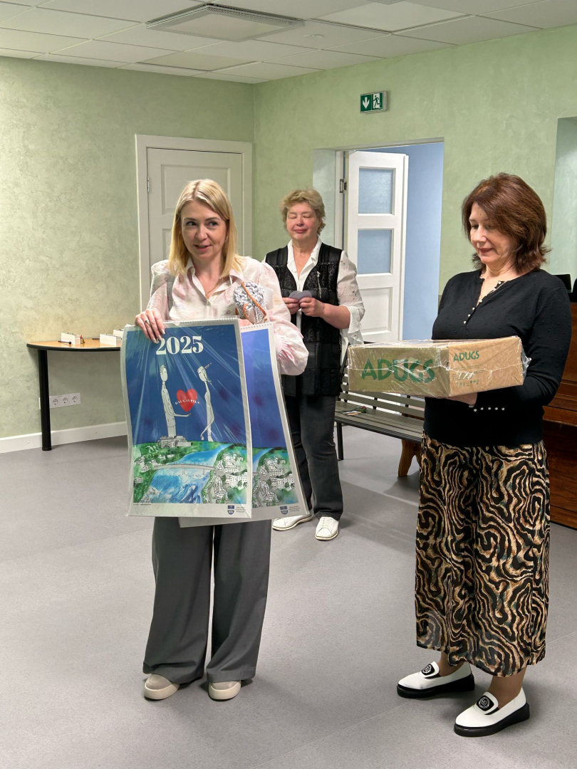 2 sievietes tur rokās dāvanas