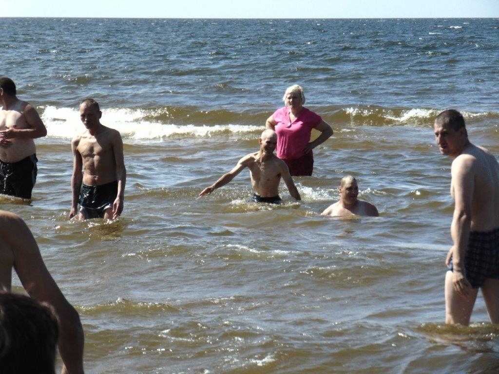 cilvēki peldas jūrā