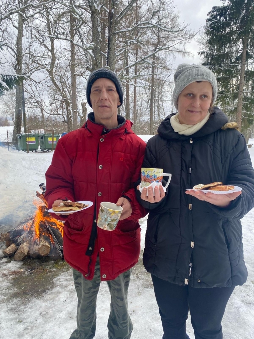 Sieviete un vīrietis pie ugunskura