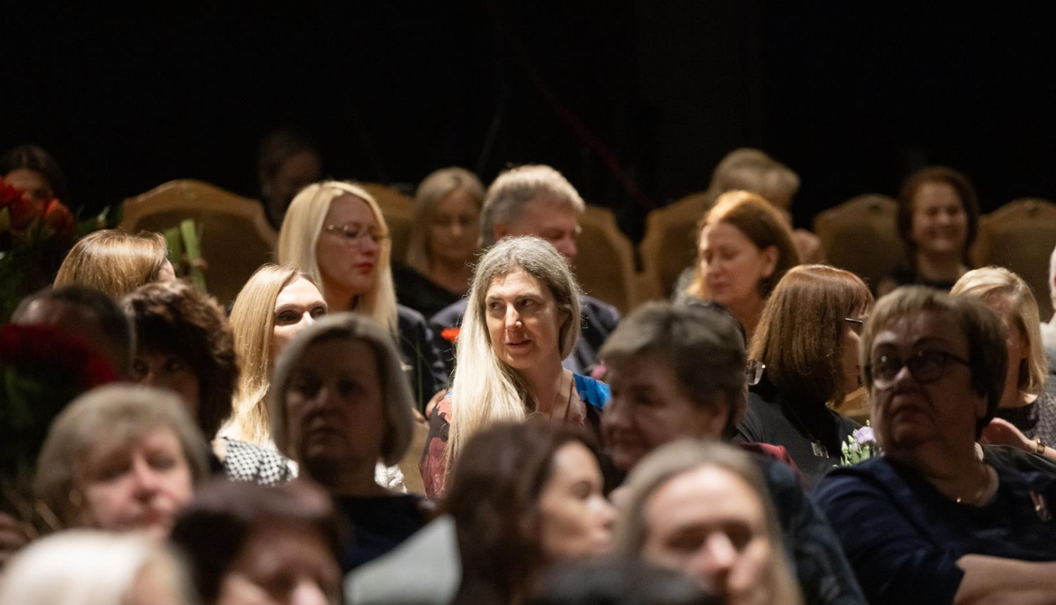 Cilvēki sēž zālē