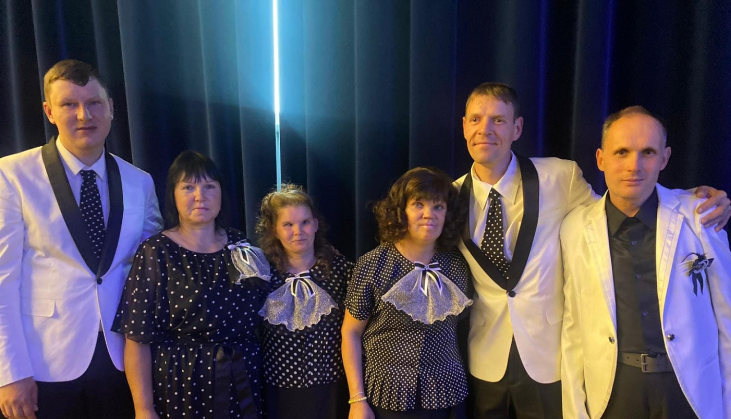 Dziedātāji uz skatuves svētku tērpos