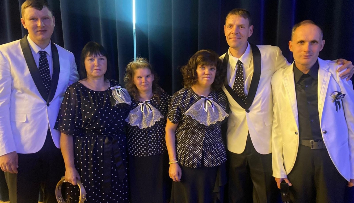 Dziedātāji uz skatuves svētku tērpos